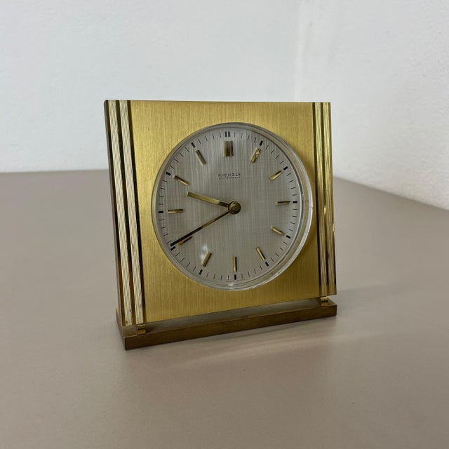 Vintage Hollywood Regency Brass Glass Table Clock from Kienzle, Germany, 1960s, in Very Good conditions. This piece is...