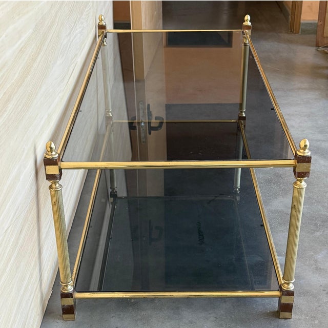 Mid-Century Modern two-tier brass and mirror beveled glass side table in Maison Jansen style with fluted brass legs and foot.