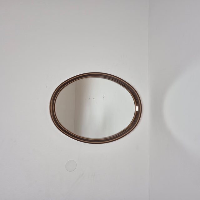 This vintage mirror features a layered acrylic glass frame in warm brown tones, creating a bold, almost graphic outline....