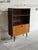 This elegant mid-sized Bookcase features upper open display shelving sitting above a lower drop-front cabinet compartment....