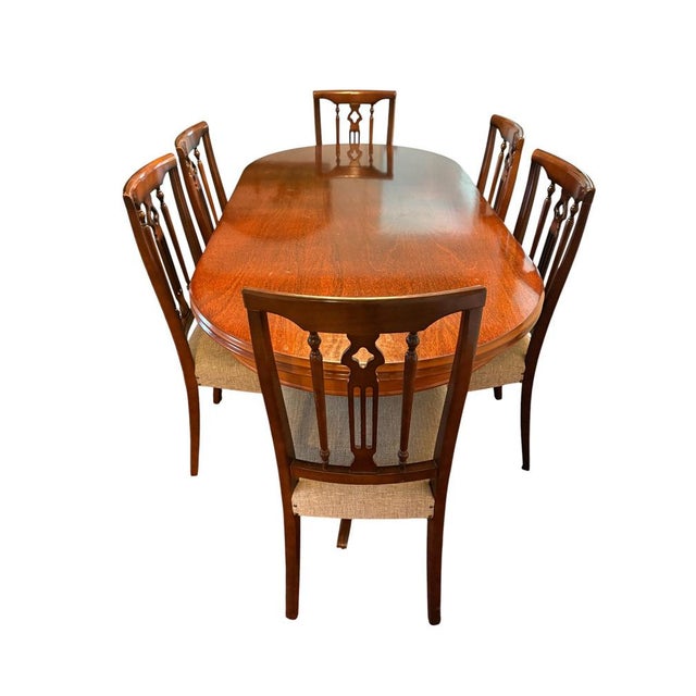 Elegant dining set consisting of an extendable oval table and six matching chairs. The table features a double pedestal...