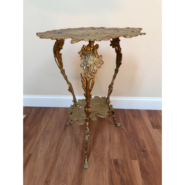 Vintage Art Nouveau style pedestal side table in gold-toned cast metal, featuring a pierced top with flowing florals and a...