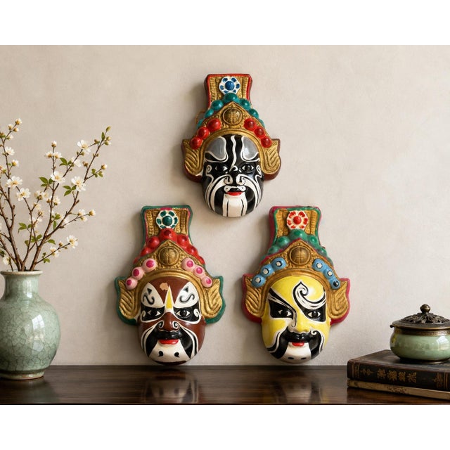 A wonderfully colorful set of three vintage Chinese hand-painted wall masks inspired by the elaborate painted-face...
