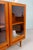 A teak display cabinet with a calm, clean aesthetic and a form that is pleasantly understated yet immediately eye-...