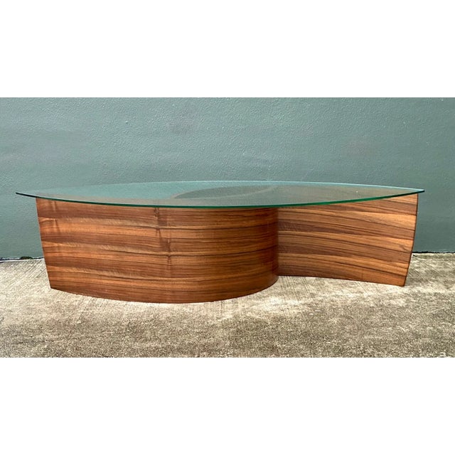 This vintage hand-made cyclone coffee table pairs a sweeping wooden base with an elliptical glass top. Carefully curved...