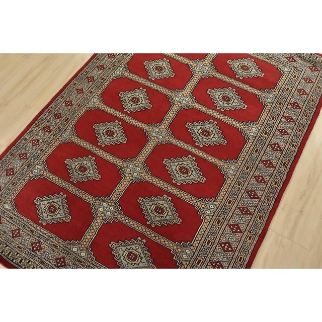 A tribal Bokhara Jaldar rug hand-knotted with fine wool on a cotton foundation. This rug features rows of repeating...