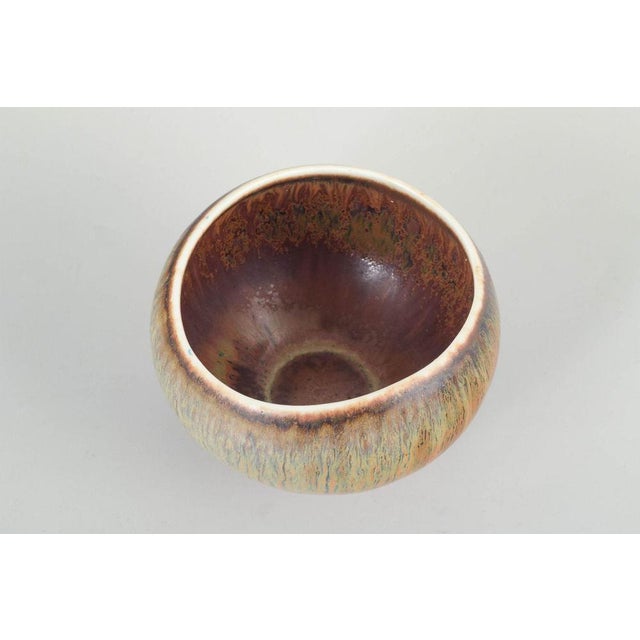 Gunnar Nylund for Rörstrand Bowl, mid-20th century. Stoneware bowl with multicoloured glaze in green, pink, and brownish...