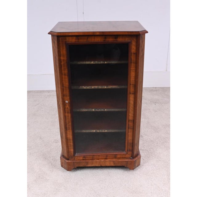Victorian walnut music cabinet with a glazed front door opening to reveal sectional shelves for storing sheet music with...