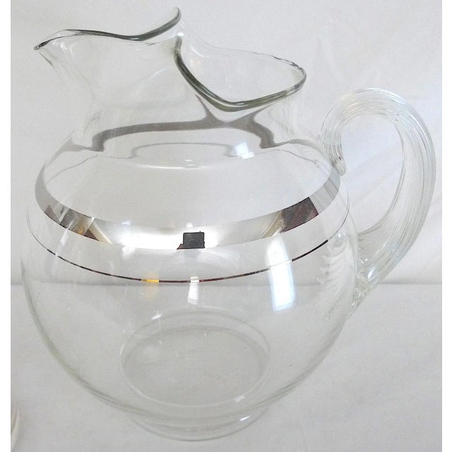 About this Item: This mid century modern glass barware set features a silver band design, includes two cocktail pitchers...