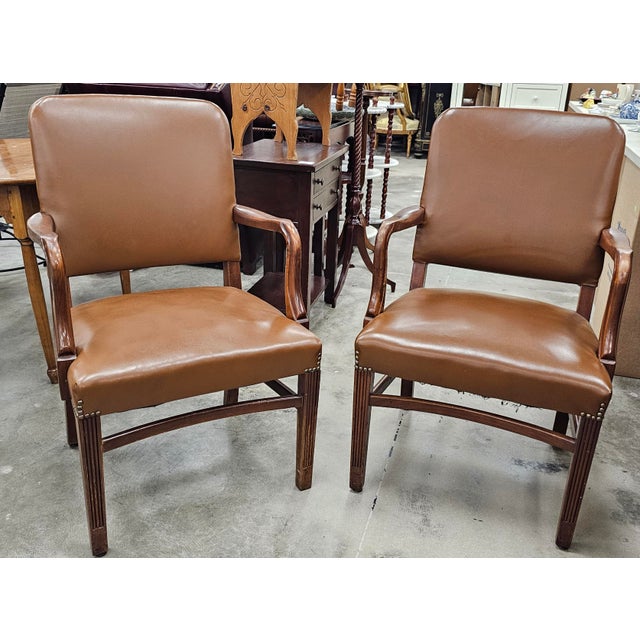A Pair of Gunlocke Georgian Style Mahogany and Vinyl Upholstered Armchairs. Measures 23.5" in width x 25" in depth x 37"...