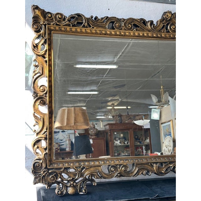 Mirror with carved wooden frame in Baroque style. The frame has a gold lacquer. The mirror is in perfect condition while...