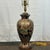 Signed Bradburn Gallery table lamp with brass finial and fittings. The base is hand painted in black, gold, green, and...