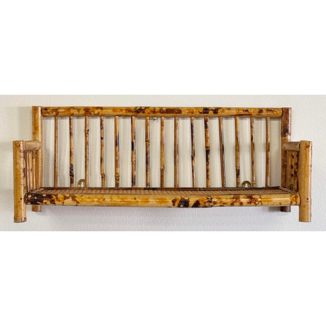 Vintage bamboo wall shelf featuring leather bindings and caned shelf surface. Would be ideal for a bathroom, small...