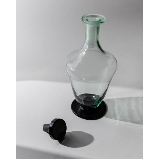 This vintage Murano glass decanter from 1960s Italy is a striking sculptural piece crafted in deep dark green art glass...