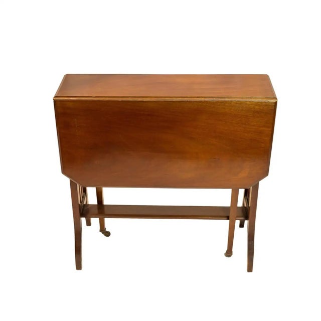 two canted-form mahogany drop-leaves, on an Arts & Crafts, slated and flared base, with central stretcher bar, and two...
