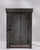 A simple and functional cabinet with a rustic aesthetic, emphasizing practicality over ornamentation. The aged wood and...