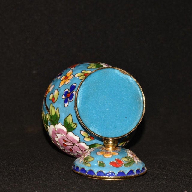 This elegant vintage covered jar is a beautiful example of cloisonné enamel artistry. The body features a bright turquoise...