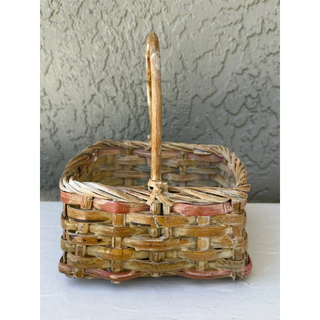 Small vintage basket. Square shaped with handle. Light natural color with pink highlights and white washing. Measures 7...