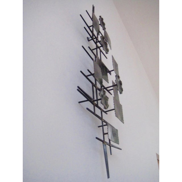 Midcentury Brutalist Mixed metal wall sculpture. The frame is iron with metal sculptural shapes in a dark green and black...