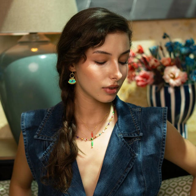 Add a burst of vibrancy and protection to your look with the Spirit Fish Orange Enamel Gold Necklace. The bold orange...