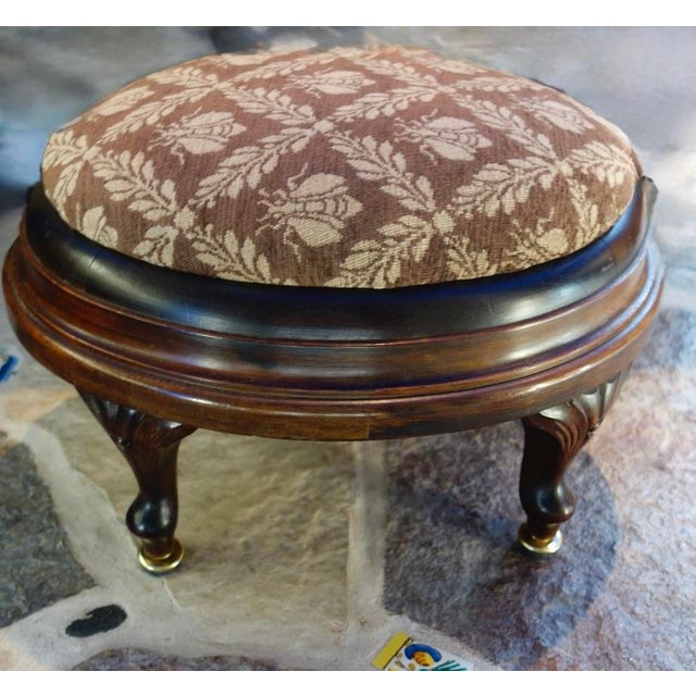 Unusual amount of wood (walnut) on this smallish stool. Covered in a warm brown cotton velour studded with ivory colored...