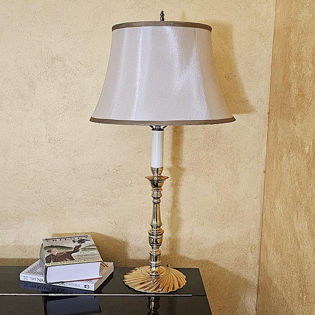 A sophisticated vintage Glenn Nelson table lamp crafted in polished brass, featuring a classic candlestick silhouette with...