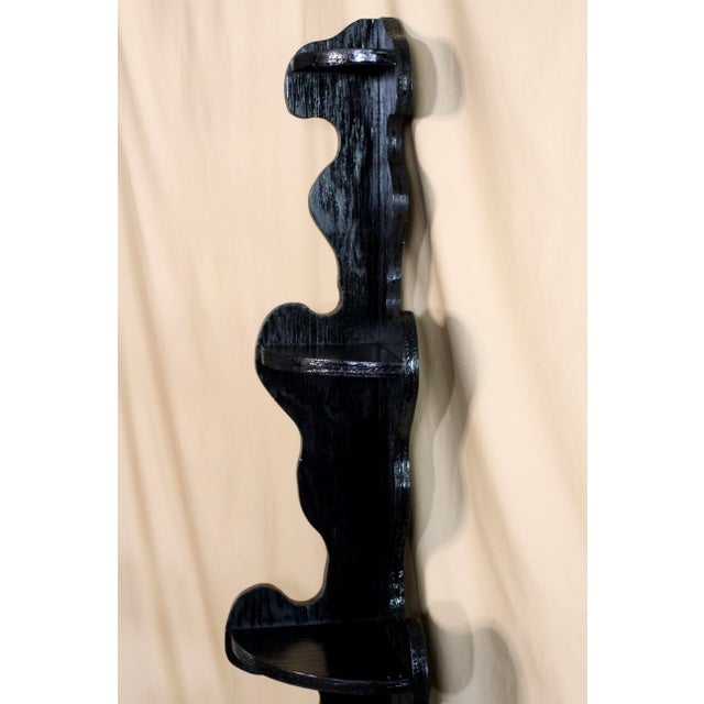 Handmade folk art black painted scroll shelf that stands in the corner. Stands tall and thin with a distinct silhouette. 5...