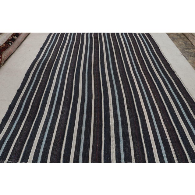 Originating from Turkey in the 1950s, this vintage mid-century wool kilim hails from a distinct family of contemporary...