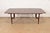 A sleek and stylish Mid-Century Modern sculpted walnut boat-shaped extension dining table Attributed to Lenoir Furniture...