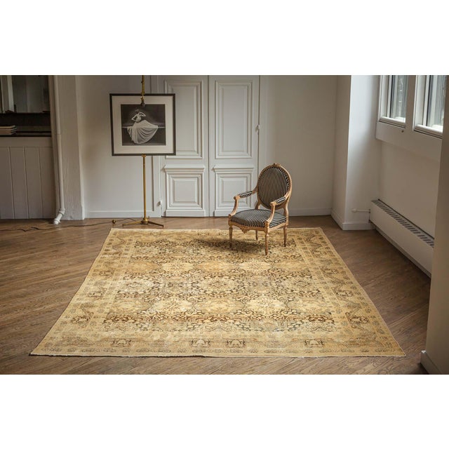 An early 20th century Antique Tabriz rug from Northwest Persia, the abrashed brown field with an ornate allover design of...