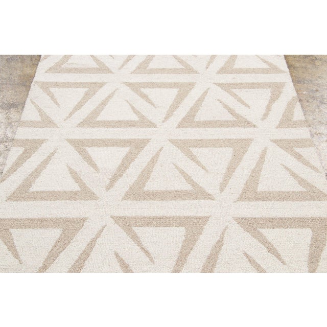 Hand-tufted in wool, this 4x6 contemporary geometric rug showcases an allover nested triangle pattern in soft beige and...