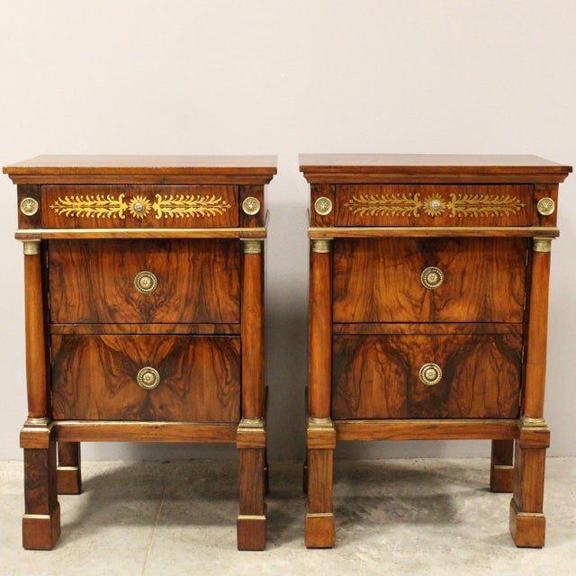 Pair of Empire bedside tables Made of solid walnut, veneered in walnut and walnut burl, elegantly inlaid and trimmed with...