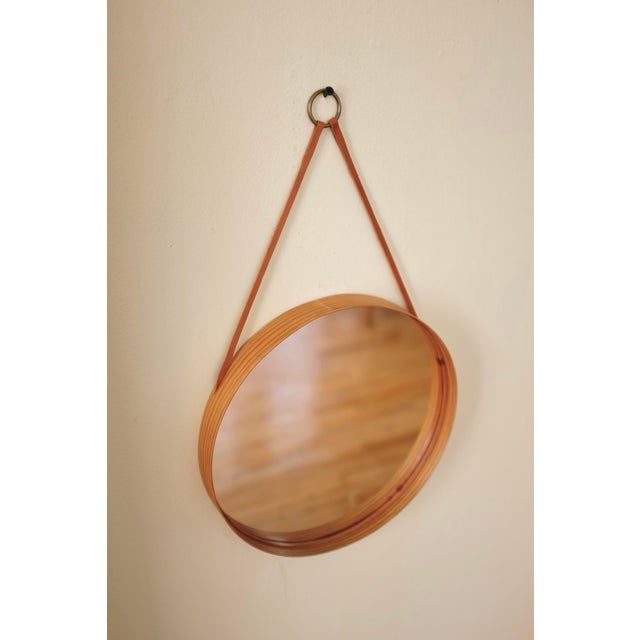 1960s Pine Wall Mirror by Nils Troed for Glasmäster, Sweden. Beautiful round pine frame with a leather trim running...