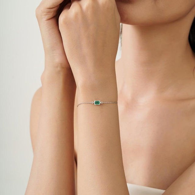 A refined 925 sterling silver chain bracelet featuring a natural emerald in a classic octagon cut (4 x 6 mm). The rich...