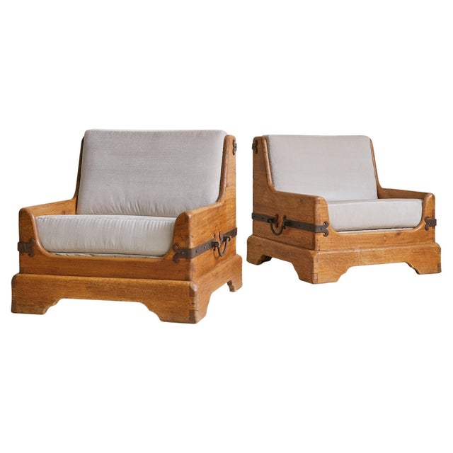 Sold and priced individually. A 1950s French armchair hewn from solid oak, its architectural frame defined by weighty...