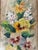 A graceful floral composition signed E. Barton, featuring golden daffodils, richly shaded pansies, delicate white flower...