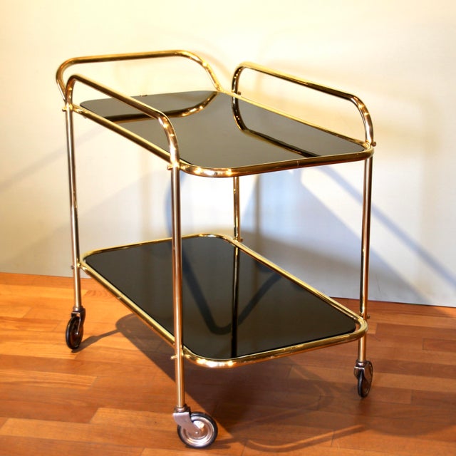 This bar cart was made in Germany in the 1950s. The elegant shape made of solid brass is typical 1950s design. The upper...