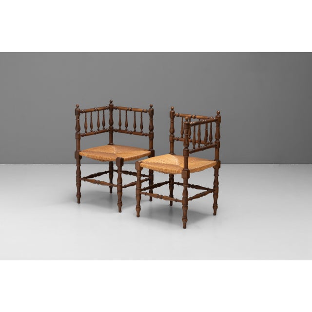 Pair of Provençal corner chairs in walnut with turned rails and rush seats. Circa 1920.