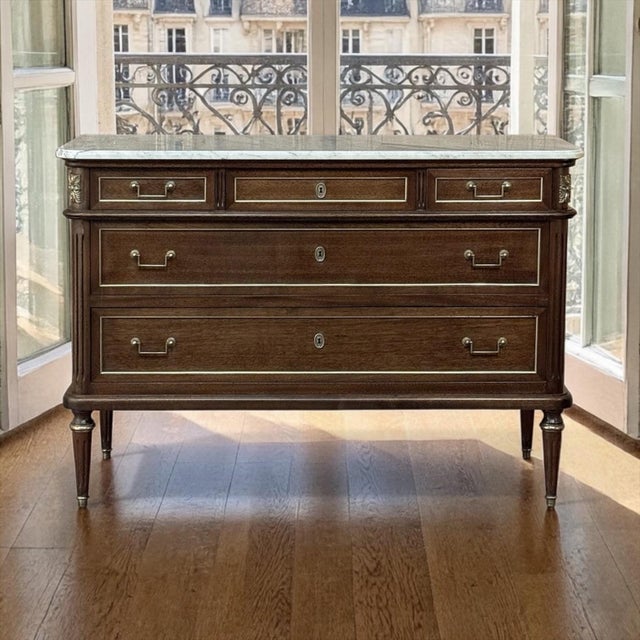 Elegant and architectural, this French Directoire neoclassical commode brings together the disciplined line of the period...