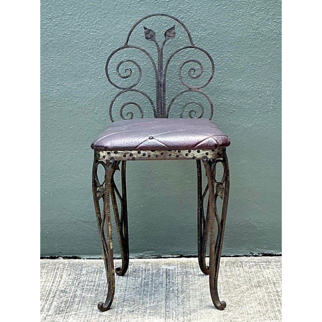 This elegant vintage vanity chair captures the essence of Mid-Century Hollywood Regency style with its ornate wrought iron...