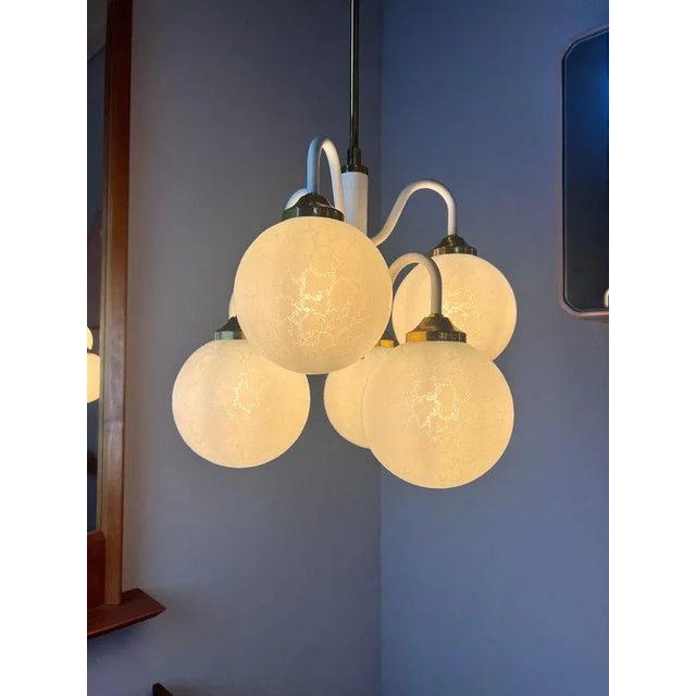 The chandelier has been refurbished. We replaced the brass canopy, renewed the cables, and installed LEDs. All globes are...