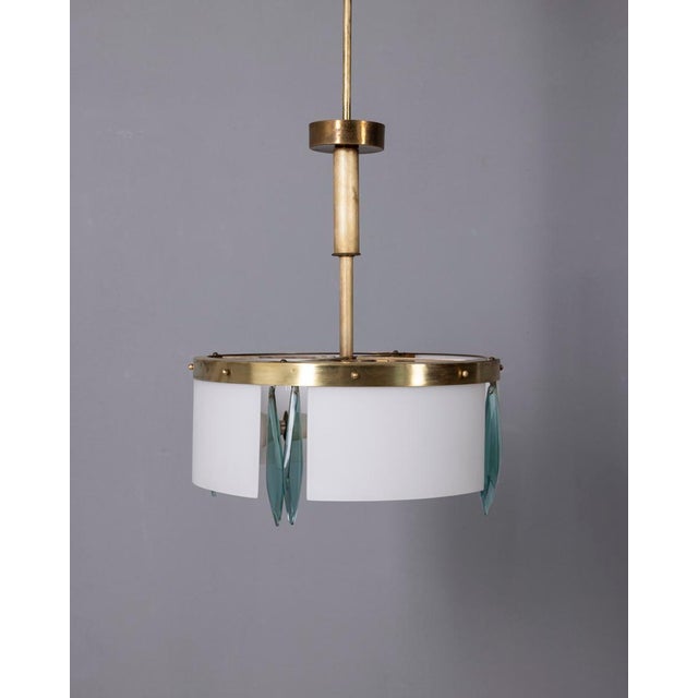 Chandelier with gilded brass structure and satin white glass lampshades and blue pendants, Italian design, 1950s. Up to...