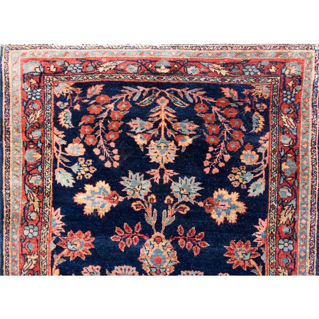 A gorgeous early 20th century Persian Sarouk rug with a central medallion surrounded by a mirrored floral pattern with...