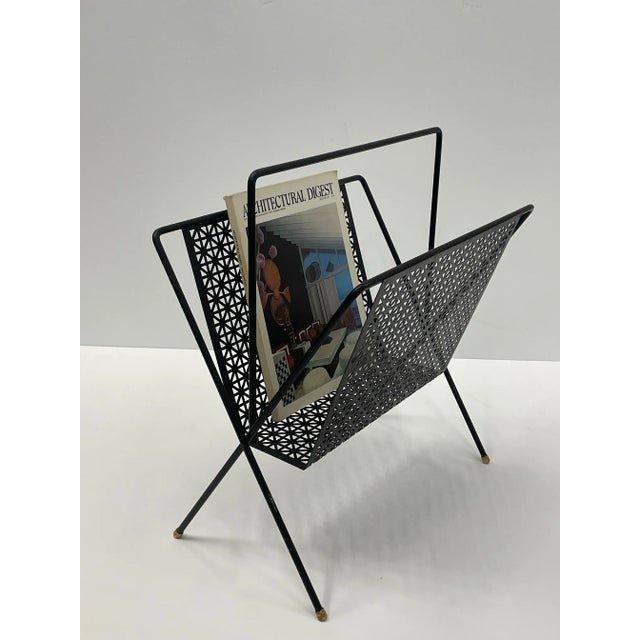 Great design in this Mid-Century Modern black iron magazine rack in the style of Hungarian artist, Mathieu Matégot.