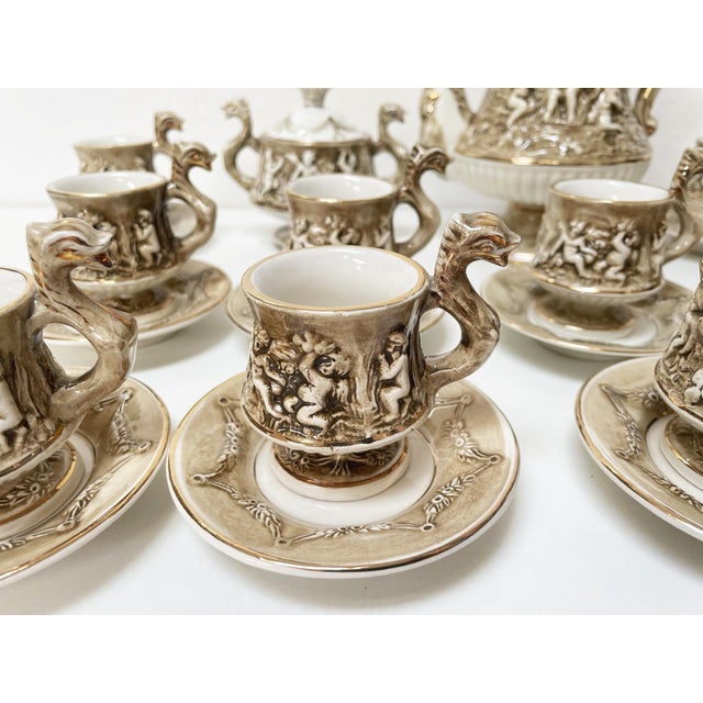 The R. Capodimonte coffee service is a true treasure, with delicate and enchanting decorations of beige embossed cherubs...