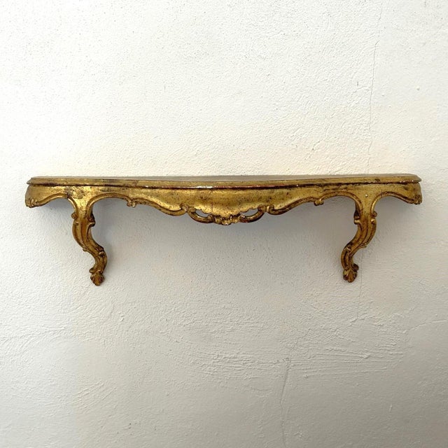A lovely Italian demilune wall bracket with carving and curves reminiscent of the Rococo period, but simplified for less...