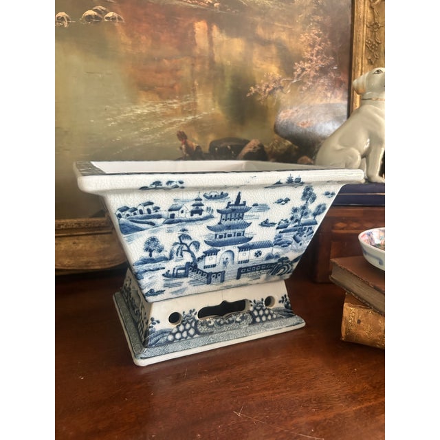 A handsome blue and white porcelain cachepot by Wong Lee, decorated in the traditional Canton taste with pagodas, bridges,...