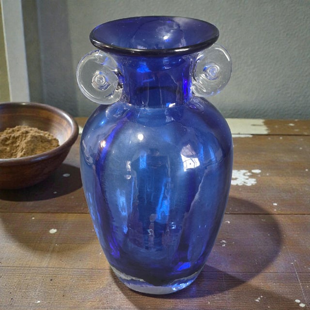 This vintage hand blown art glass vase features a stunning cobalt blue neoclassical design, showcasing the exquisite...