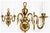 A charming vintage plated brass wall sconce with two curved arms, white candle-style lights, and beautiful antique...