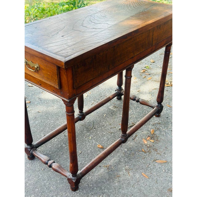 A handsome antique English walnut writing table featuring a rich, warm patina and elegant understated craftsmanship. This...